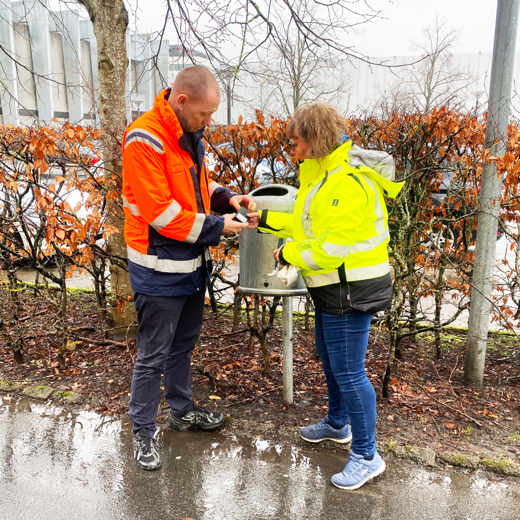 Mand og kvinde ved siden af en skraldespand